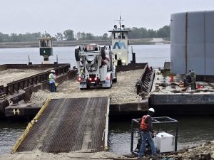 A Bleigh Ready Mix concrete truck is transported on a river barge.